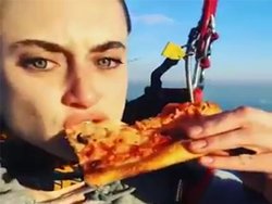 Une fille mange une pizza en parachute